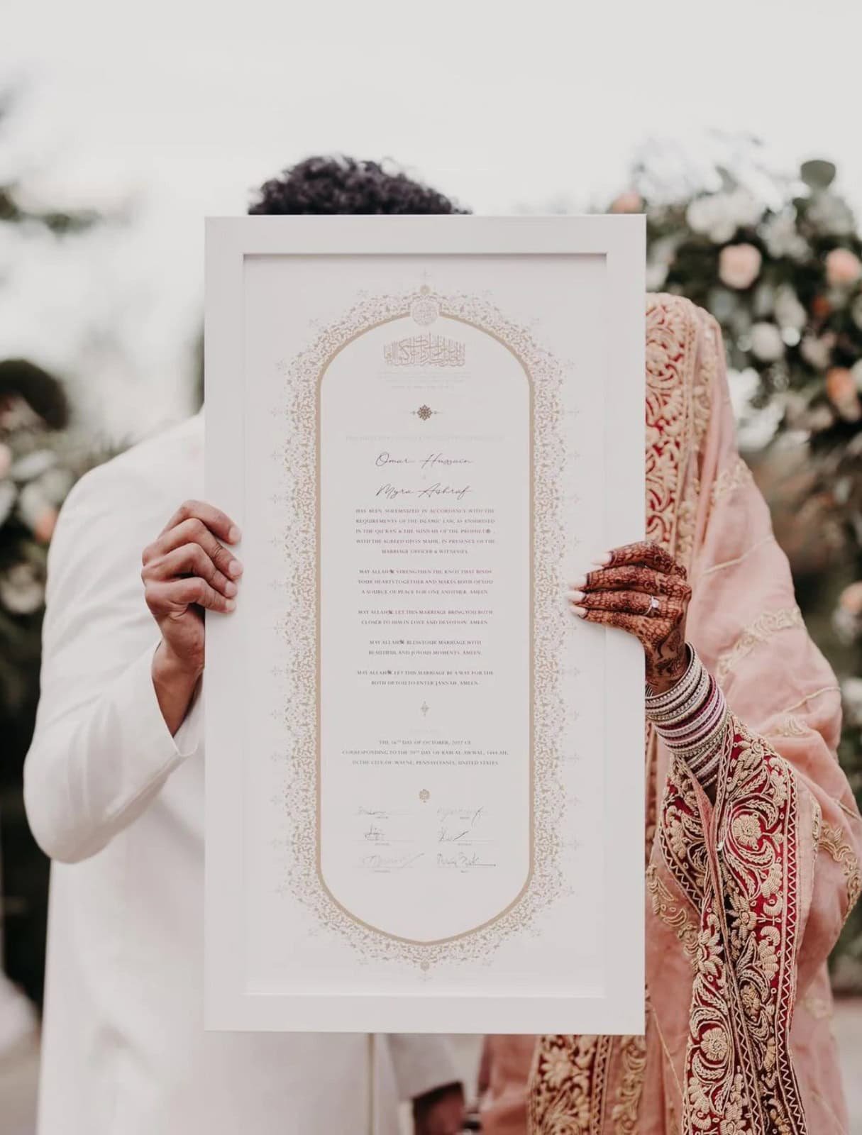 Couple holding authentic handcrafted Nikkah certificate by The Framers