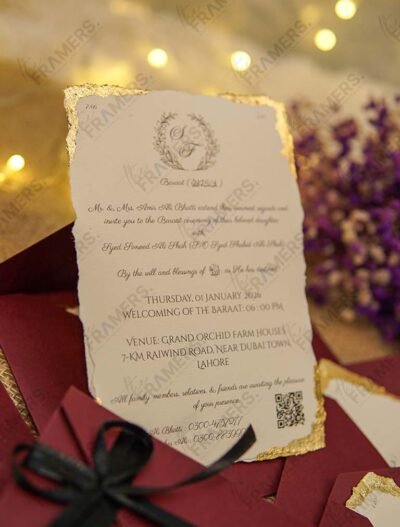 Burgundy wedding invitation envelope with gold wax seal and black satin ribbon